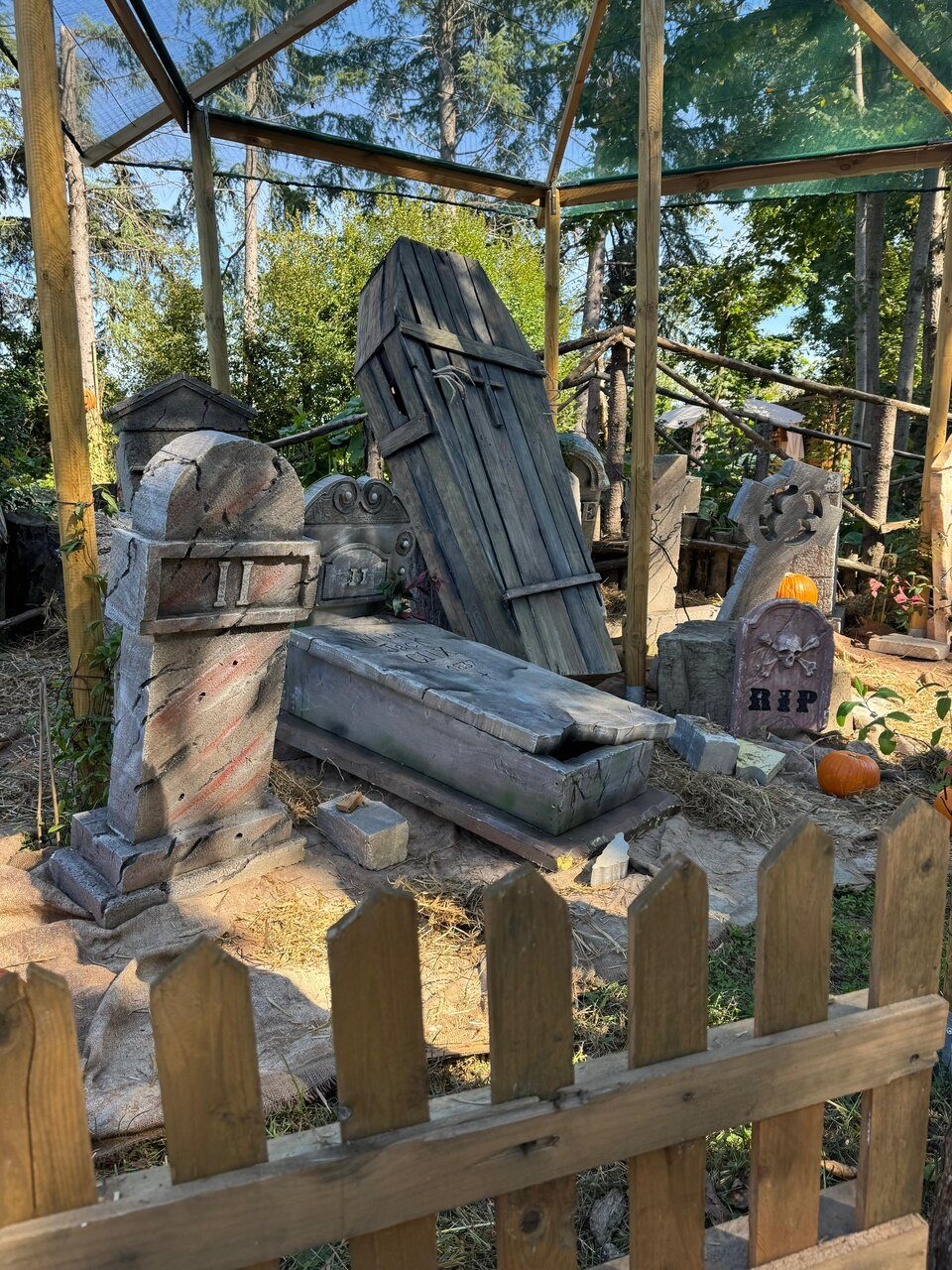 Il cimitero spettrale del Campo di Zucche con lapidi, bara di legno e staccionata